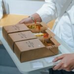 A woman holding a tray of food in her hands