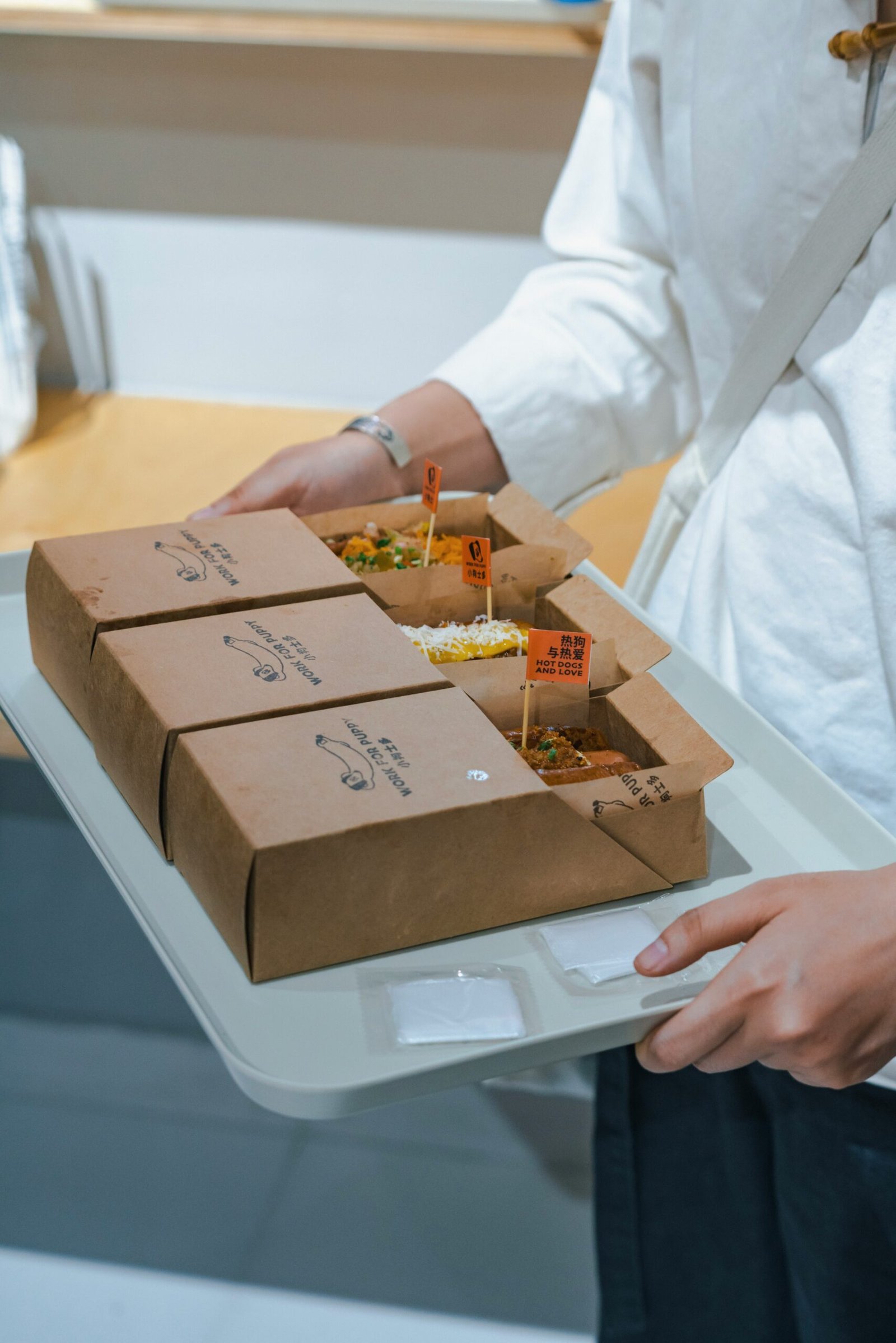 A woman holding a tray of food in her hands